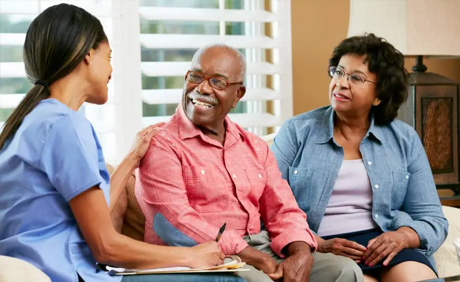 Caregiver with Smiling Elderly Couple