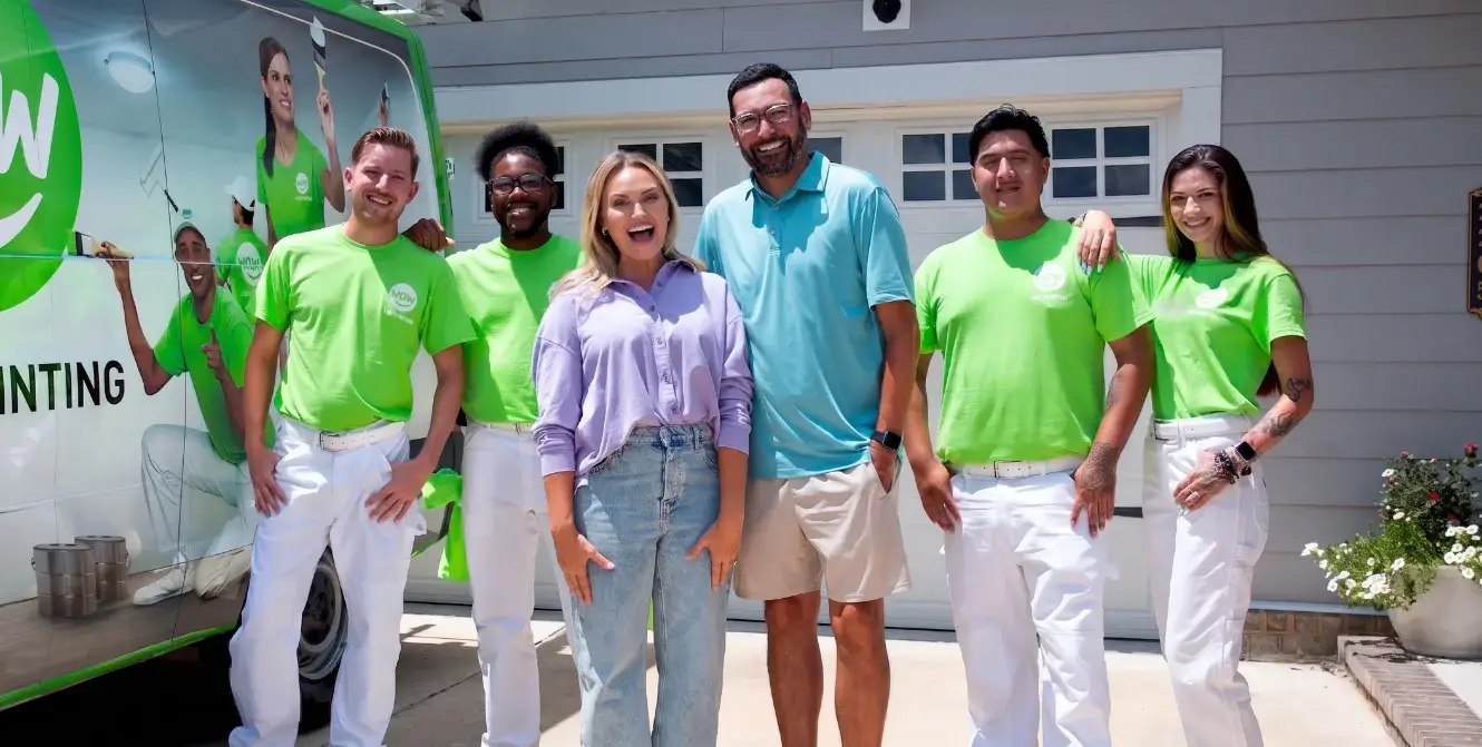 The WOW 1 Day Painting team with happy homeowners in front of the branded company van