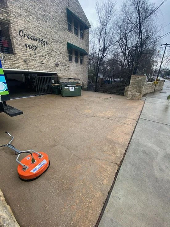 Powerwashing a commercial dumpster pad