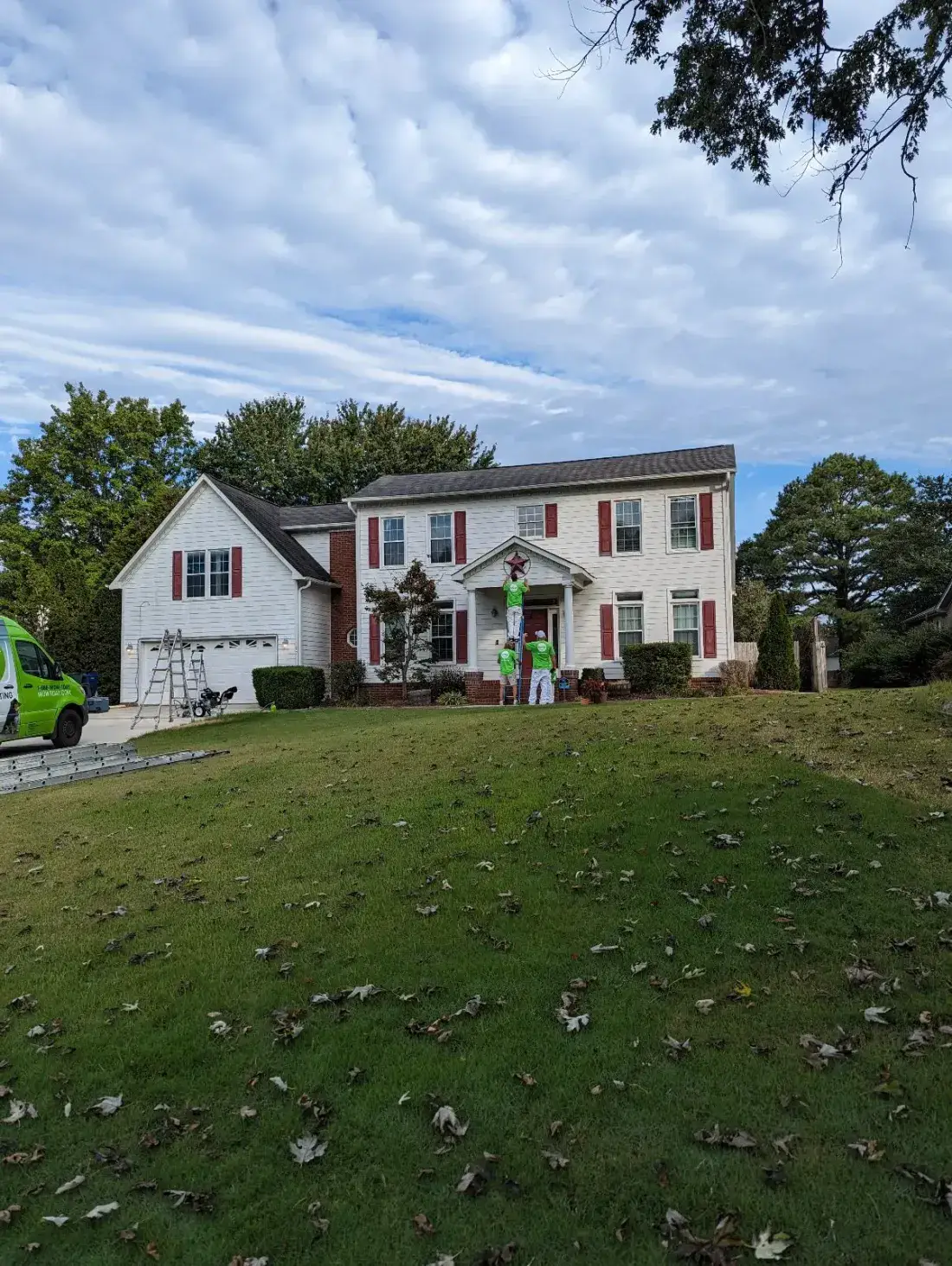 Before — Two-storey home exterior repainted white with gold shutters