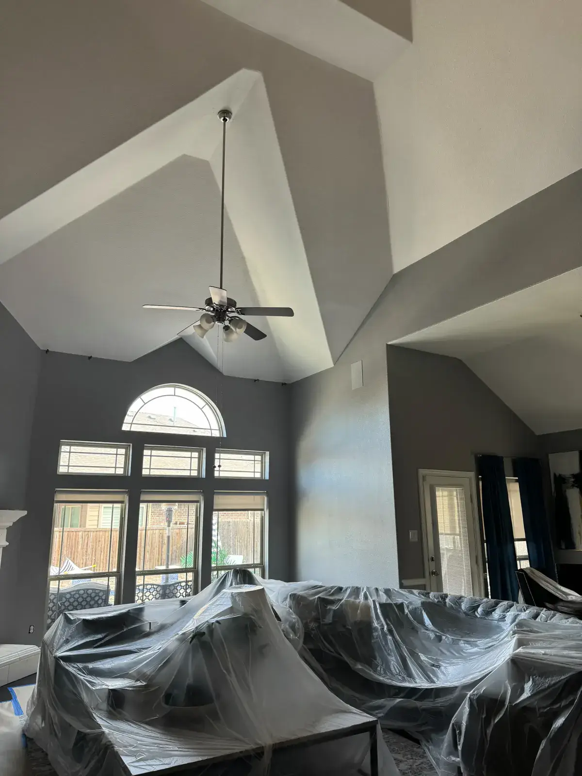 Before — Freshly painted living room with a vaulted ceiling and arched window