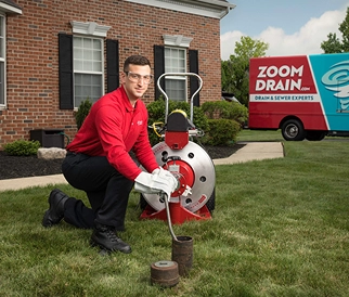 Plumbing technician working at an outdoor sewer line access point