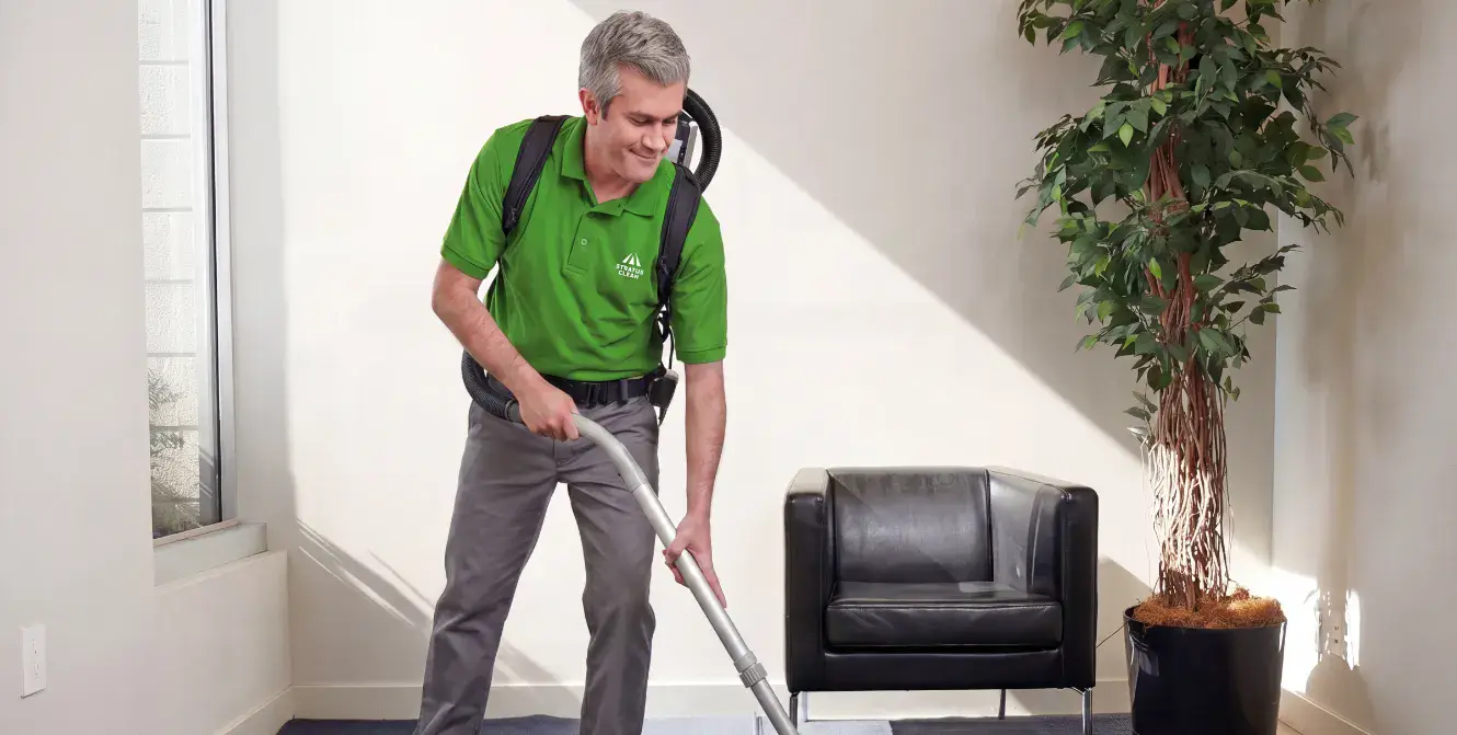 Stratus Clean technician vacuuming a commercial office floor